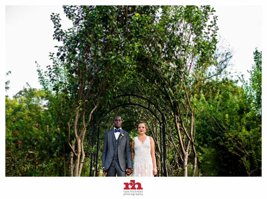 A wedding couple hold hands in front of an archway at the elkridge furnace inn.